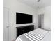 Modern bedroom with a large TV, dark dresser, and neutral colored bed at 454 Pender Woods Dr, Summerville, SC 29486