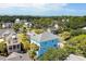 Aerial view of the blue house, showcasing nearby mature trees and surrounding properties at 74 Sandbar Ln, Folly Beach, SC 29439