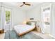 Cozy bedroom with a modern bed, bright windows, white curtains, and a decorative rug at 74 Sandbar Ln, Folly Beach, SC 29439