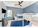 Charming bedroom featuring bunk beds, blue walls, a ceiling fan, and a bright window at 74 Sandbar Ln, Folly Beach, SC 29439