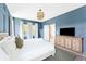 This bedroom features blue walls, hardwood flooring, and a stylish console table with decor at 74 Sandbar Ln, Folly Beach, SC 29439