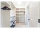 Organized walk-in closet with shelves, hanging space, and wood flooring at 74 Sandbar Ln, Folly Beach, SC 29439