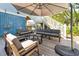 Comfortable deck with gray furniture, an umbrella, and access to the lush backyard at 74 Sandbar Ln, Folly Beach, SC 29439