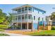 Stunning three-story home with double porches, lush landscaping, and ample outdoor space at 74 Sandbar Ln, Folly Beach, SC 29439