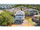 Stunning elevated beach home with a blue exterior, covered balconies, and lush landscaping at 74 Sandbar Ln, Folly Beach, SC 29439