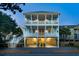 Three-story coastal home with double porches, convenient ground-level parking and great lighting for evening ambiance at 74 Sandbar Ln, Folly Beach, SC 29439