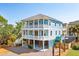 Charming three-story coastal home with double porches, landscaping and convenient ground-level parking at 74 Sandbar Ln, Folly Beach, SC 29439