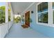 Inviting covered porch featuring wood door, white railings, and ceiling fan at 74 Sandbar Ln, Folly Beach, SC 29439
