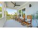 Comfortable porch featuring four rocking chairs with plush pillows, a ceiling fan and scenic outdoor views at 74 Sandbar Ln, Folly Beach, SC 29439