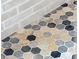 Close-up of shower floor with stylish gray, black, and beige hexagon tile with light grout at 74 Sandbar Ln, Folly Beach, SC 29439