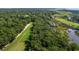 An aerial view highlights a lush golf course with mature trees along the coast with marsh and waterway and bridges at 807 Treeloft Trce, Seabrook Island, SC 29455