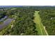 An aerial view captures the intersection of a verdant golf course, tranquil pond, and lush trees near a coastal waterway at 807 Treeloft Trce, Seabrook Island, SC 29455