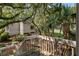 Picturesque view from a wooden deck with a table and chairs overlooking a house nestled among trees and a golf course at 807 Treeloft Trce, Seabrook Island, SC 29455
