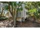 Exterior view of a home with trees, a small deck, and stairs leading to a peaceful retreat at 807 Treeloft Trce, Seabrook Island, SC 29455