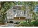 Charming raised home featuring a neutral exterior, lush landscaping, and inviting staircase at 807 Treeloft Trce, Seabrook Island, SC 29455