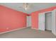 A bedroom with coral walls featuring a window and closet, offering ample space and storage at 9998 Winged Elm St, Ladson, SC 29456