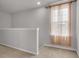 A hallway area with neutral carpeting, a large window, and natural light at 9998 Winged Elm St, Ladson, SC 29456