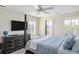 Bedroom featuring a four-poster bed, ceiling fan, TV, shuttered windows, and dresser at 10 Ocean Point Dr, Isle of Palms, SC 29451