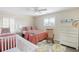 Bedroom featuring twin beds, ceiling fan, shuttered windows and turtle themed rug at 10 Ocean Point Dr, Isle of Palms, SC 29451