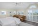 Bedroom featuring vaulted ceiling, shuttered windows, dresser, and comfortable rattan seating area at 10 Ocean Point Dr, Isle of Palms, SC 29451