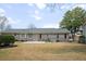 Spacious backyard featuring a brick house with a grey roof, green trees and a lawn at 1043 Dominion Dr, Hanahan, SC 29410