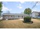 Spacious backyard featuring a brick house with a grey roof, green trees and a lawn at 1043 Dominion Dr, Hanahan, SC 29410