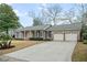 Attractive brick home with a two-car garage, surrounded by green lawns and lush landscaping that enhances its curb appeal at 1043 Dominion Dr, Hanahan, SC 29410
