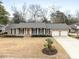 Charming brick home with a two-car garage, complemented by a well-manicured lawn and a tasteful front yard landscaping at 1043 Dominion Dr, Hanahan, SC 29410