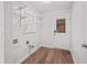 Bright laundry room with wood floors, shelving, utility connections and access door at 1043 Dominion Dr, Hanahan, SC 29410