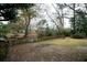 A spacious backyard with mature trees and a wooden fence bordering a small creek for added privacy at 1075 Quail Dr, Charleston, SC 29412