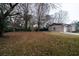 A large backyard with a brick house, mature trees, and a garage, perfect for outdoor activities and relaxation at 1075 Quail Dr, Charleston, SC 29412
