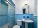 Retro bathroom featuring blue tile shower, pedestal sink, and charming details at 1075 Quail Dr, Charleston, SC 29412