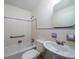 Vintage bathroom features white tile with light purple trim, pedestal sink, and shower-tub combo at 1075 Quail Dr, Charleston, SC 29412