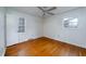 Cozy bedroom features hardwood floors, ceiling fan, and two windows for natural light at 1075 Quail Dr, Charleston, SC 29412
