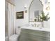 Well-lit bathroom with green vanity, brass fixtures, and decorative mirror at 1119 Simmons St, Mount Pleasant, SC 29464
