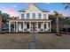 Charming white farmhouse with a covered porch, perfect for enjoying serene evenings at 1119 Simmons St, Mount Pleasant, SC 29464