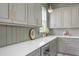 Charming kitchen with light gray cabinetry, white countertops, gold hardware and fixtures, and wood-look floors at 1119 Simmons St, Mount Pleasant, SC 29464
