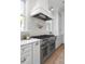 Well-equipped kitchen with a stainless steel range, marble countertops, and custom cabinetry with brass hardware at 1119 Simmons St, Mount Pleasant, SC 29464