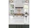 Kitchen island with marble countertop, brass faucet and hardware, and a brick backsplash behind the range at 1119 Simmons St, Mount Pleasant, SC 29464