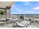Outdoor lounging on balcony with ocean view, featuring white lounge chairs and a small table at 112 Ocean Blvd, Isle of Palms, SC 29451