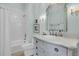 Charming bathroom with custom vanity, tiled shower and tub combination, and decorative light fixtures at 112 Ocean Blvd, Isle of Palms, SC 29451