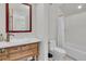 Traditional bathroom with wood vanity, white walls, and white shower and toilet at 112 Ocean Blvd, Isle of Palms, SC 29451