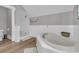 A neutral bathroom has a soaking tub with a white tiled surround and a glass enclosed shower at 112 Ocean Blvd, Isle of Palms, SC 29451