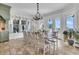 Bright dining room with ocean views, large windows, stylish chandelier, and adjacent gourmet kitchen at 112 Ocean Blvd, Isle of Palms, SC 29451