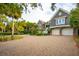 Elegant home with a brick driveway, lush landscaping, and a three-car garage at 112 Ocean Blvd, Isle of Palms, SC 29451