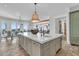Kitchen island with sink, seating, and a view of the dining area with a chandelier at 112 Ocean Blvd, Isle of Palms, SC 29451