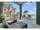 Inviting outdoor patio featuring comfortable seating and a serene view of the lush tropical landscaping at 112 Ocean Blvd, Isle of Palms, SC 29451