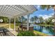 Outdoor kitchen with grill and pergola next to a serene pond with a fountain feature at 130 River Landing Dr # 5108, Charleston, SC 29492