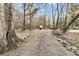 Gravel driveway with a trailer and mature trees, offering privacy and country charm at 135 Rapture Ln, Wando, SC 29492