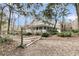 Charming two-story home with a large wrap-around porch, surrounded by mature trees and lush landscaping at 135 Rapture Ln, Wando, SC 29492